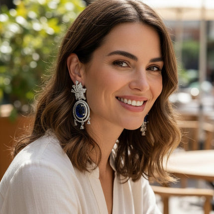 Kurti Connection USA ornate silver drop earrings with blue carved stones and clear cubic zirconia accents.