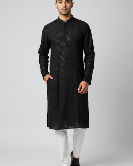 Man wearing a Kurti Connection USA black embroidered traditional kurta with a mandarin collar and side pockets.
