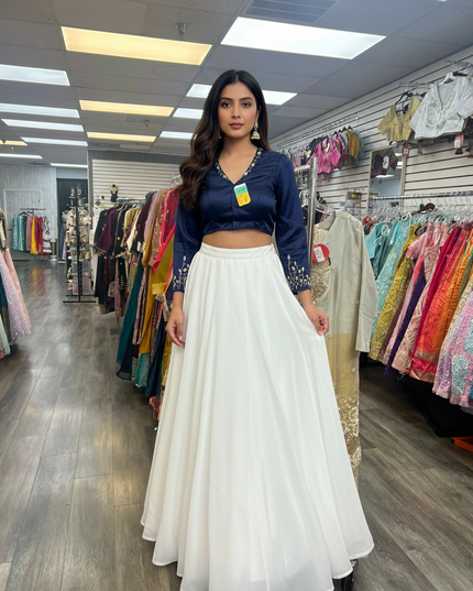 Kurti Connection USA blue blouse with embroidered sleeves paired with a long white flowing skirt in a clothing store
