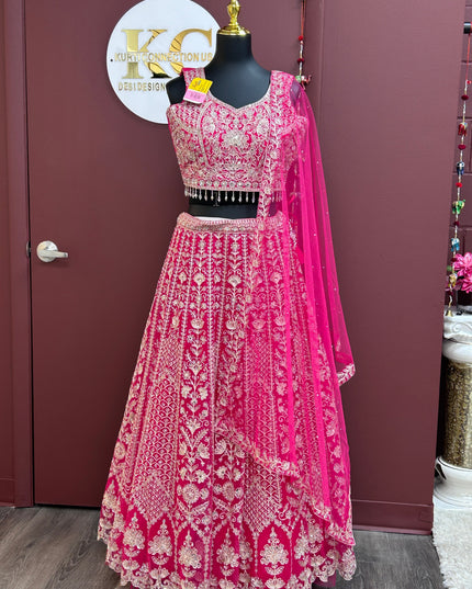 Kurti Connection USA dark pink lehenga choli set with intricate gold embroidery and matching sheer dupatta on mannequin