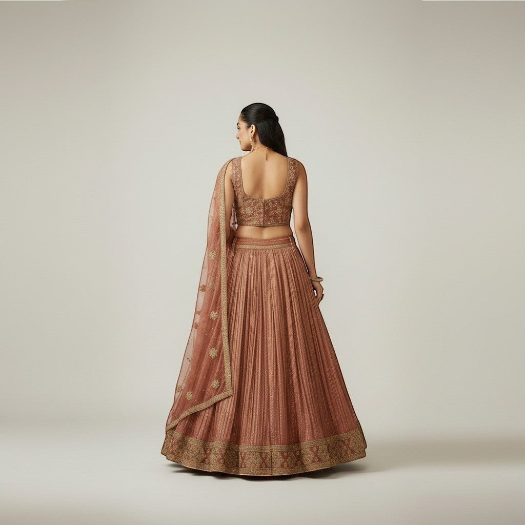 Kurti Connection USA embroidered lehenga set in warm hue with gold detailing. Features pleated skirt and ornate blouse.