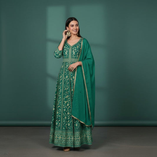 Kurti Connection USA emerald green Anarkali suit with gold embroidery and dupatta. Model wears large gold earrings.