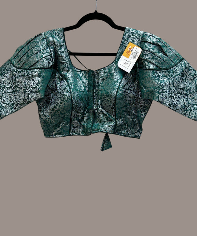 Kurti Connection USA emerald green and silver brocade blouse with puff sleeves and a square neckline on a hanger