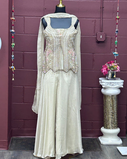 Kurti Connection USA off-white sharara set with embellished sleeveless tunic, flared pants, dupatta, and necklace.