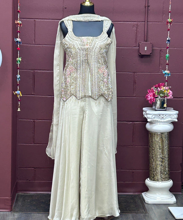 Kurti Connection USA off-white sharara set with embellished sleeveless tunic, flared pants, dupatta, and necklace.