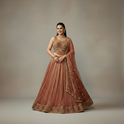 Kurti Connection USA embroidered lehenga set in warm rust with gold detailing. Sleeveless blouse and flowing pleated skirt.