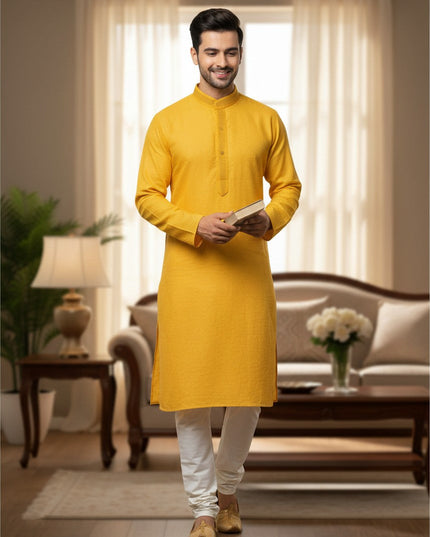 Man wearing a Kurti Connection USA yellow textured kurta with white pajama pants in a bright living room setting.